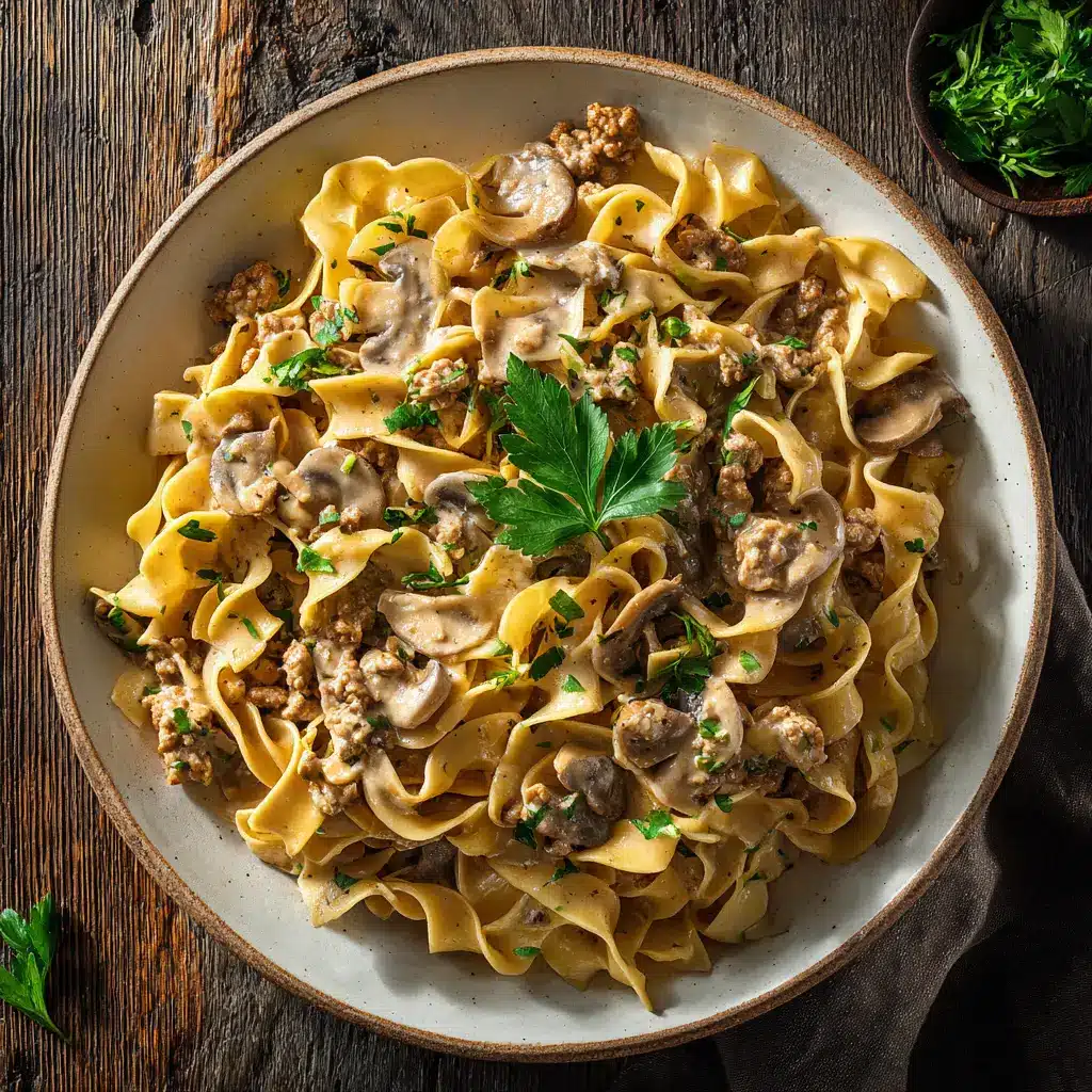 A spoonful of ground turkey pasta being lifted from a bowl, highlighting the texture of the egg noodles and sauce.