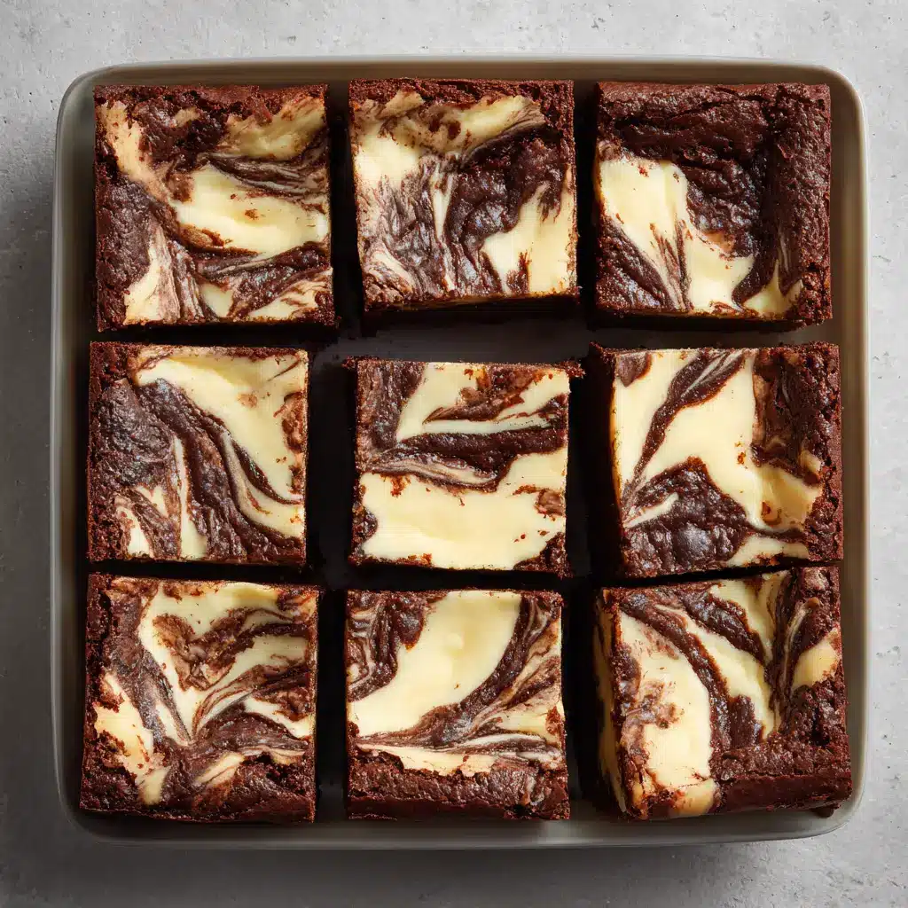 A close-up shot of cream cheese brownies being swirled with a knife before baking, demonstrating the technique for a perfect marble effect.
