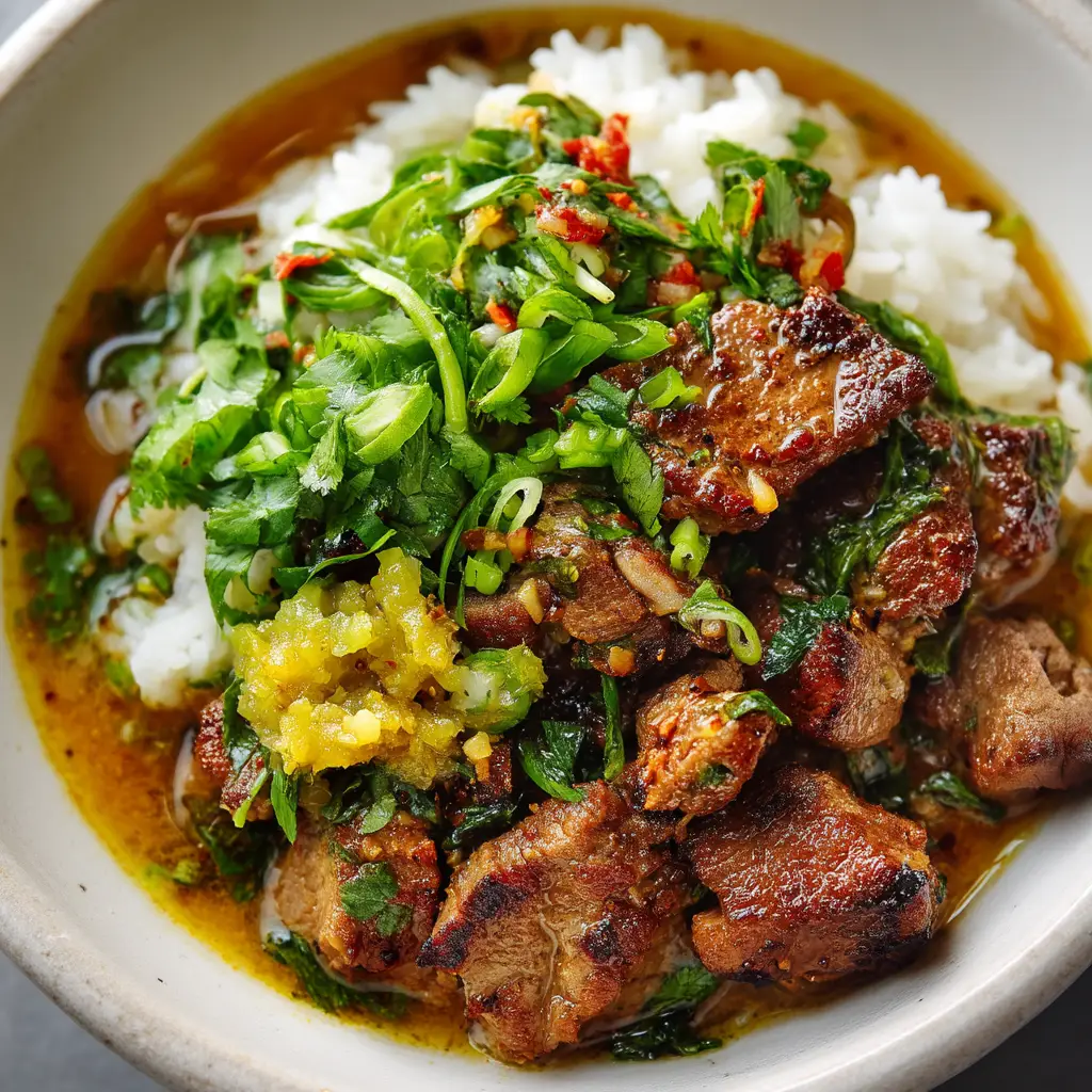 An overhead view of the crispy cumin lamb being stir-fried in a wok with aromatics and spices.