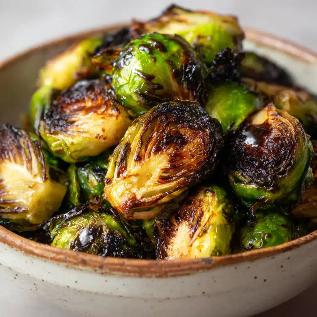 Thick, glossy, dark brown honey balsamic glaze pooling slightly in the crevices of roasted Brussels sprout leaves.