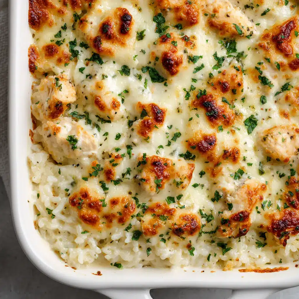 A scoop of Chicken Alfredo Rice Casserole on a plate, showing the creamy rice and chicken interior.