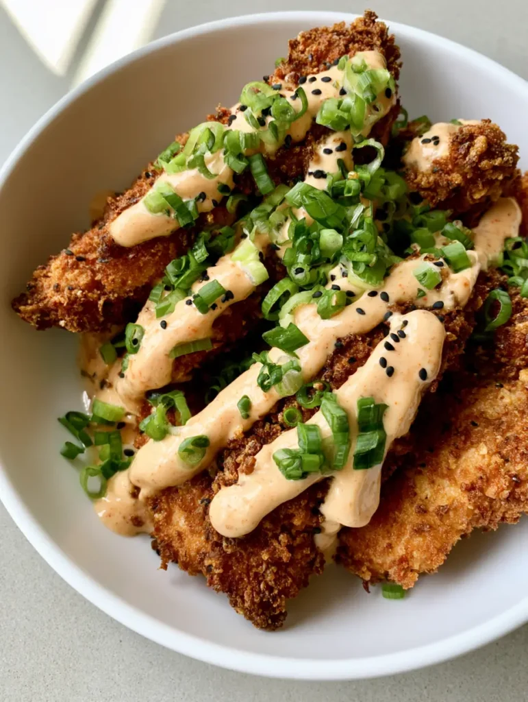 Bang Bang Chicken: The Ultimate Crispy Panko Recipe 1 A top-down view of Bang Bang Chicken showing the generous scatter of black sesame seeds and bright green scallions.